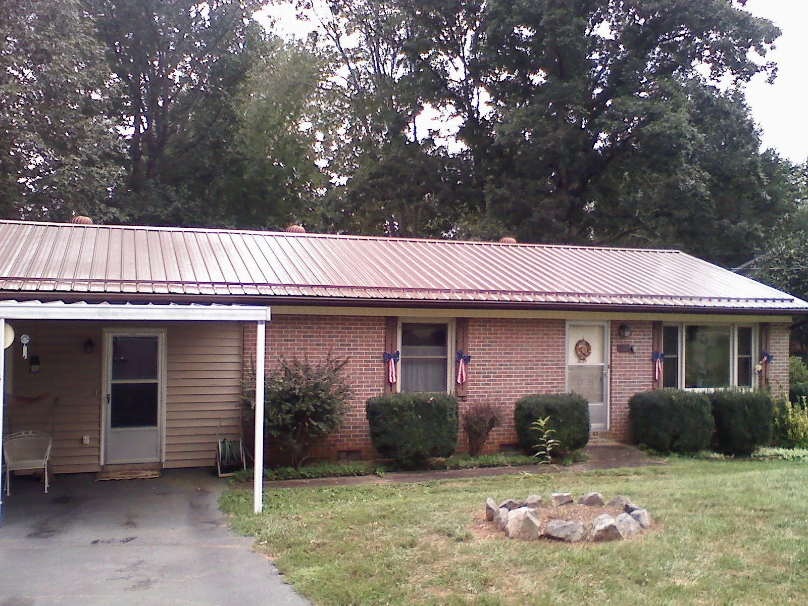 Bronze metal roof and carport on a brick ranch home — Roof Repair work by our crew in Satartia